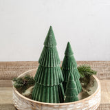 Three green velvet flocked cone trees in graduated heights grouped in a carved wood bowl
