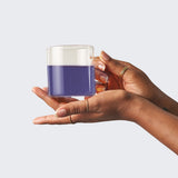 Hand holding a glass of naturally blue Minty Blue butterfly pea tea