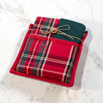 Red tartan plaid potholder with a pocket holding a folded green waffle towel tied with twine