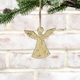 Flat hammered gold metal angel ornament hanging from jute twine on a pine branch