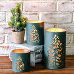 Teal green metal lanterns with gold cut-out Christmas tree designs glowing from inside