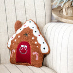 Brown sherpa gingerbread house pillow with white icing roof, polka dots, red door and candy canes