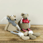 Two plush mice with long striped legs and knit scarves, one gray and one red, on a wood shelf