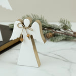 Small white wood angel with natural edges and a twine bow with wooden beads on a marble surface