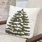 Cream square pillow with a textured loop crochet green Christmas tree on a wood-armed chair