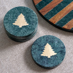Round green marble coasters inlaid with a gold Christmas tree, shown stacked and single