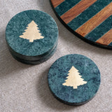 Round green marble coasters inlaid with a gold Christmas tree, shown stacked and single
