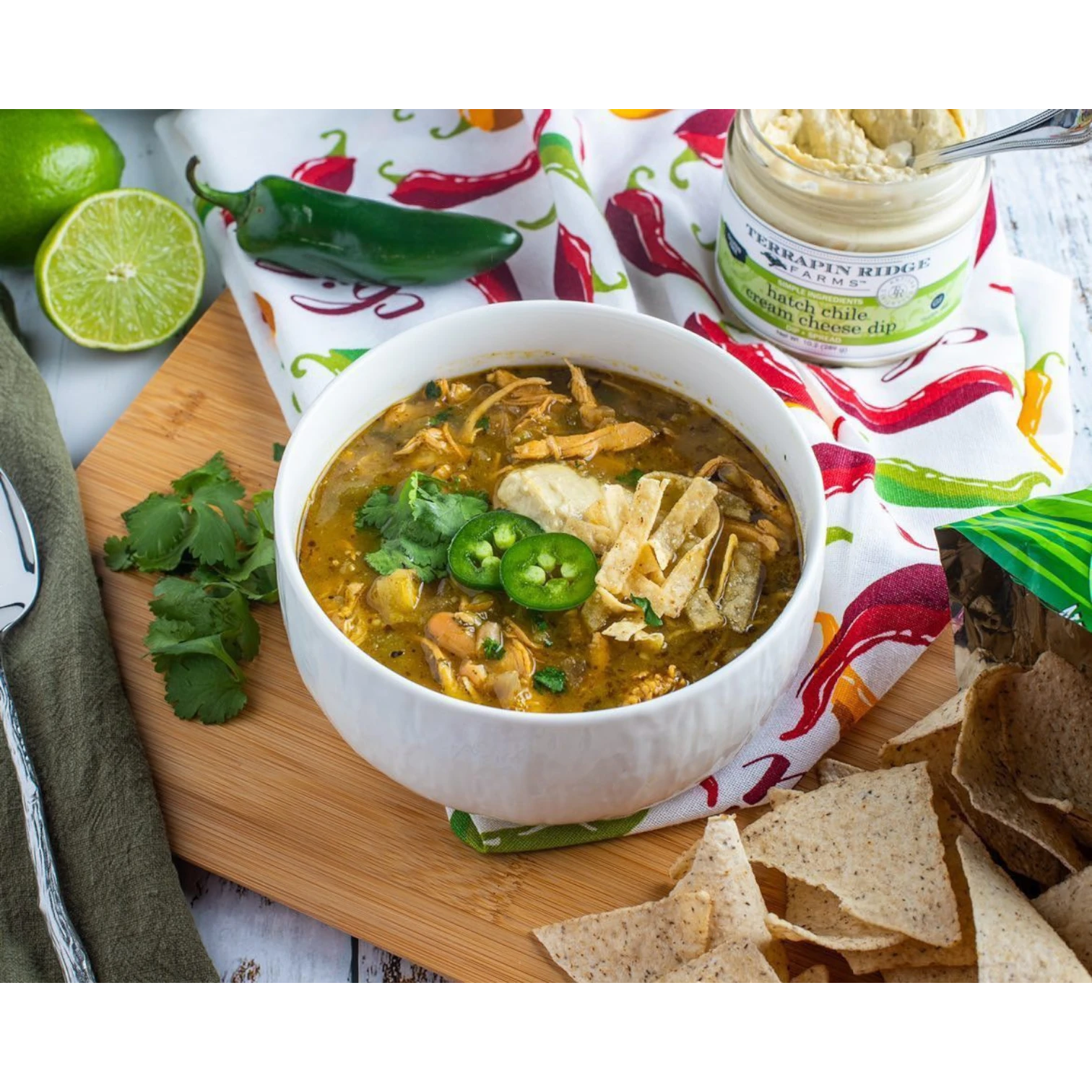 Chicken chili with jalapeños and tortilla strips beside Hatch Chile Cream Cheese Dip