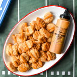 Chicken nuggets drizzled with Honey BBQ Aioli on a tailgate spread