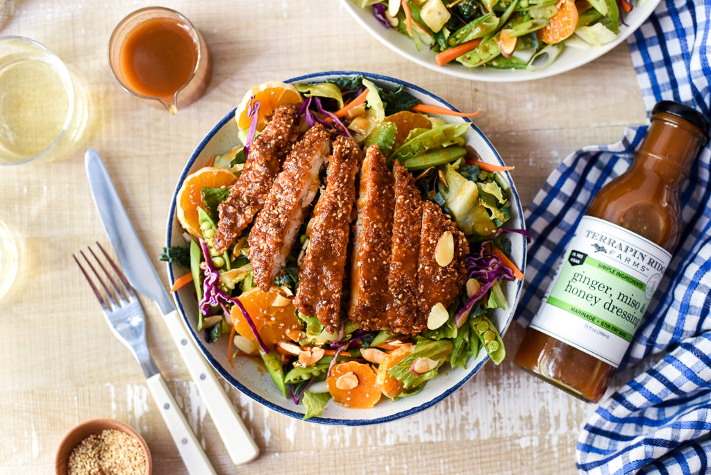 Sesame chicken salad with vegetables, oranges and almonds dressed with Ginger, Miso & Honey Dressing