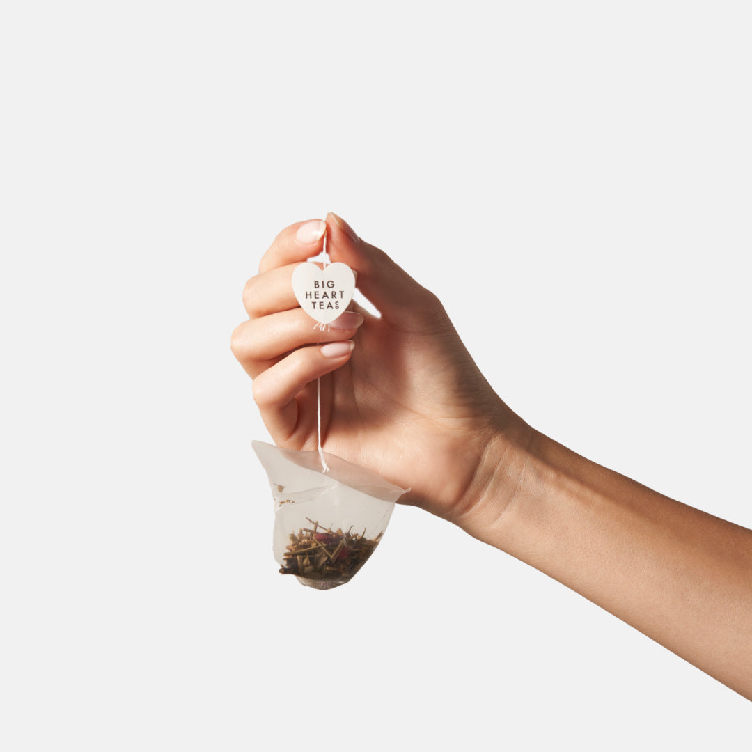 Hand holding a Big Heart Tea compostable Blushing hibiscus tea bag