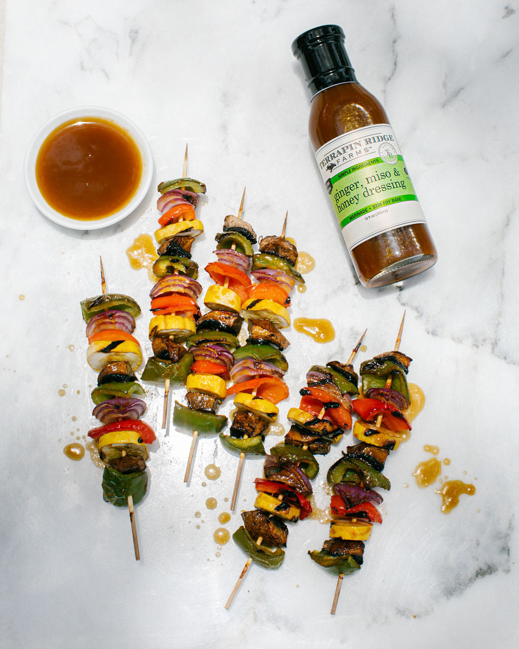 Pepper, onion and mushroom skewers with a bowl of Ginger, Miso & Honey Dressing