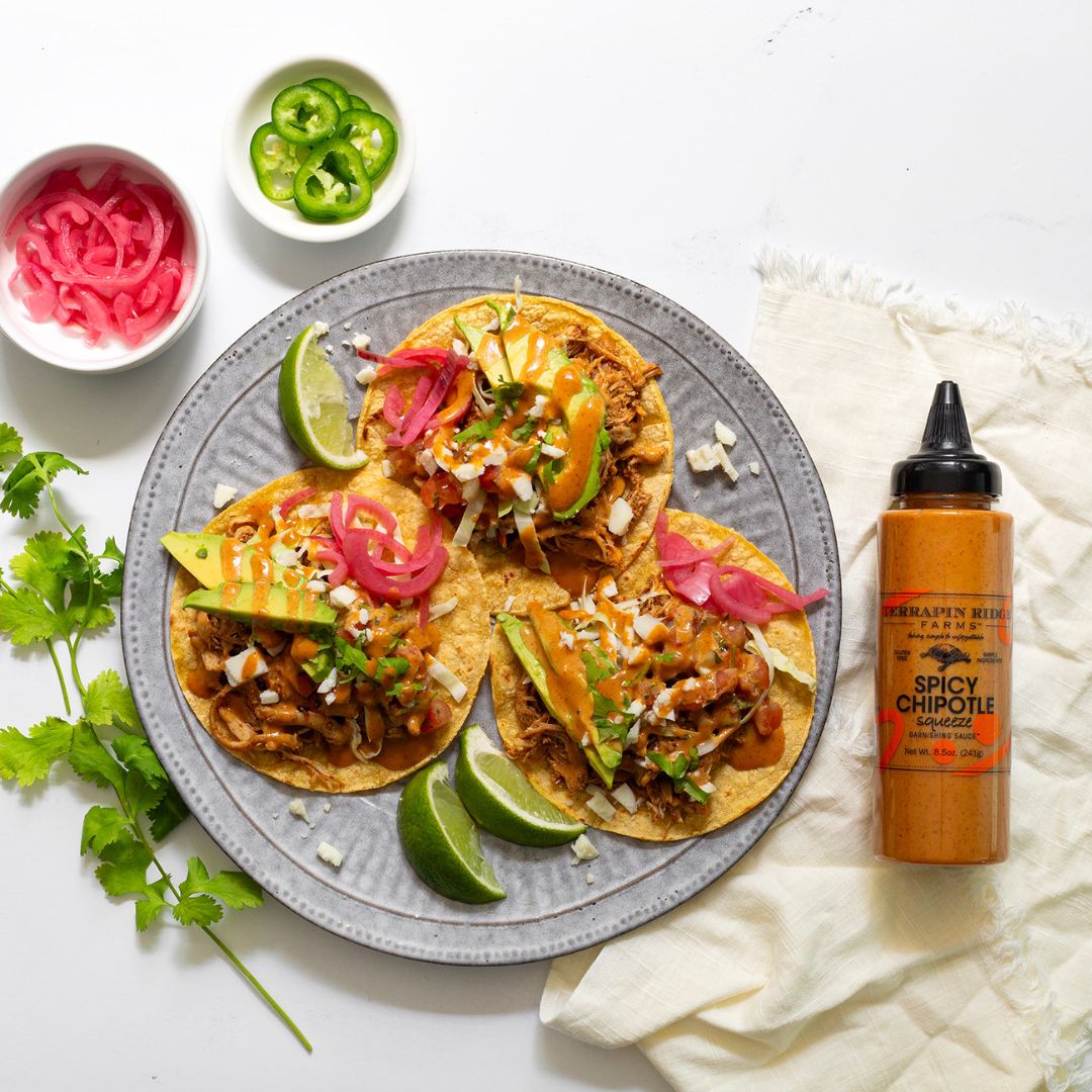 Shredded chicken tacos drizzled with spicy chipotle sauce