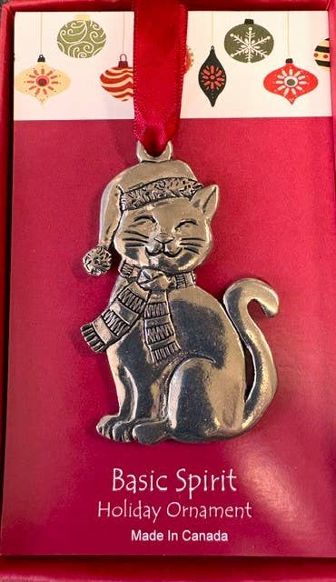 Pewter cat in a scarf and knit hat hanging from red ribbon in a red gift box with ornament print