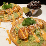 Shrimp tostadas with guacamole and cheese drizzled with Chile Lime Aioli