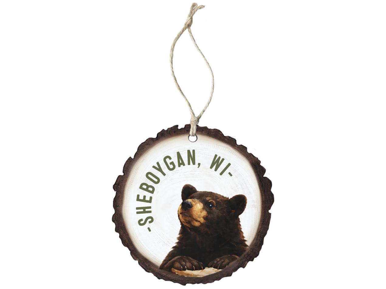 Round wood-slice ornament with a black bear and curved town name, hung on jute twine