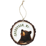 Round wood-slice ornament with a black bear and curved town name, hung on jute twine