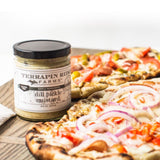 Flatbread pizzas with vegetables beside a jar of Dill Pickle Mustard