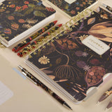 Spiral-bound art journal with a Forest Flowers illustrated cover, interior pages