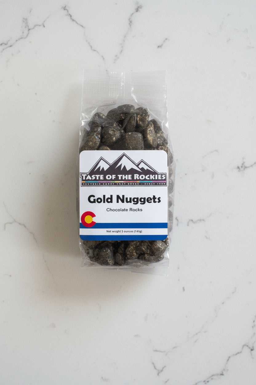 Packaged chocolate rocks labeled 'Gold Nuggets' from Taste of the Rockies on a white background with a Colorado logo.