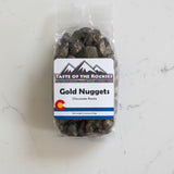Packaged chocolate rocks labeled 'Gold Nuggets' from Taste of the Rockies on a white background with a Colorado logo.