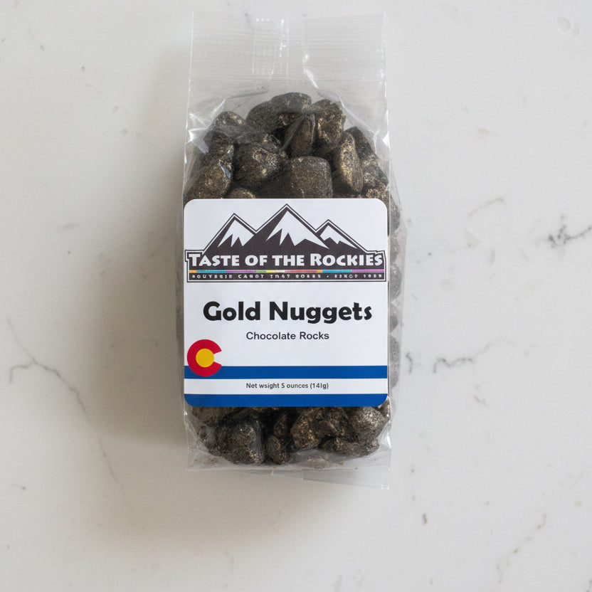 Packaged chocolate rocks labeled 'Gold Nuggets' from Taste of the Rockies on a white background with a Colorado logo.