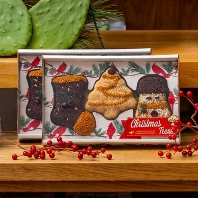 Boxed set of three seed ornaments shaped like a stocking, snowman, and tree on a wood shelf