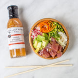 Tuna poke bowl with avocado and rice beside Pineapple & Habanero Sauce