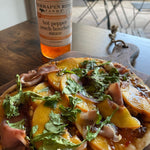 Peach and prosciutto flatbread with greens and Hot Pepper Peach Bourbon Sauce