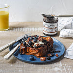 French toast topped with blueberries and pecans beside Blueberry Bourbon Pecan Jam