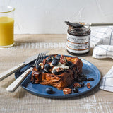 French toast topped with blueberries and pecans beside Blueberry Bourbon Pecan Jam