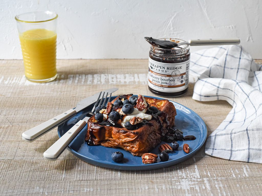 French toast topped with blueberries and pecans beside Blueberry Bourbon Pecan Jam