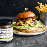 Cheeseburger and fries with a jar of Balsamic Onion Jam